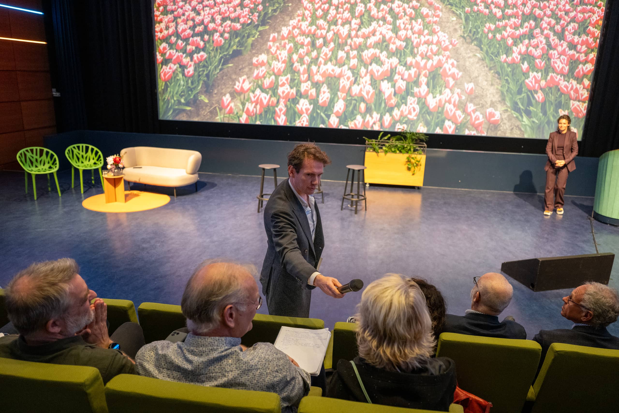 Eline van Beest spreekt aan de hand van een illustratie met een tulpenveld.
